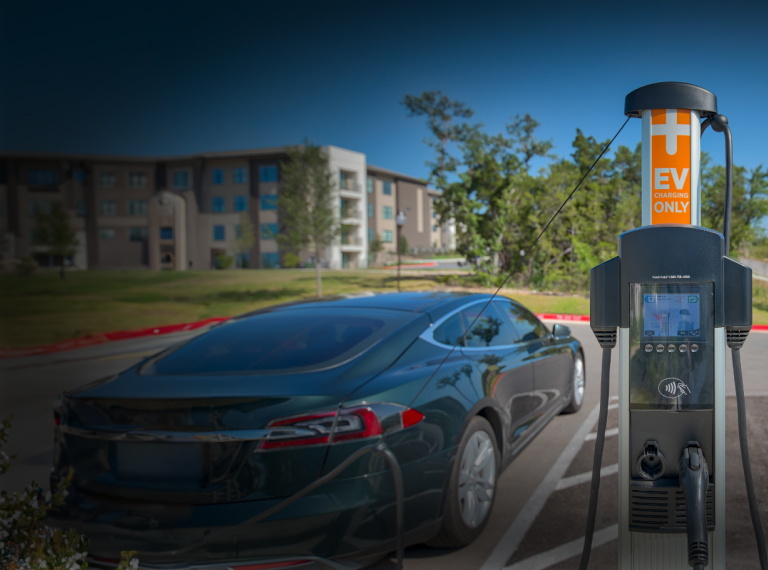 A car parked in a parking lot with an electronic vehicle charger