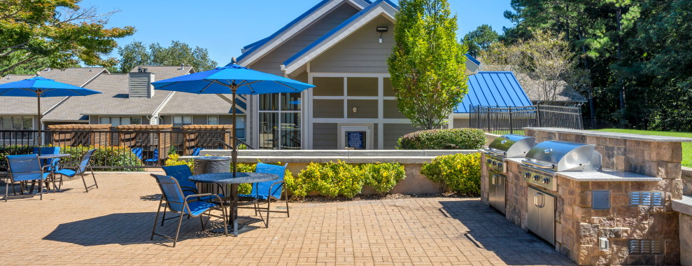 A house with a patio, barbeques and garden furniture