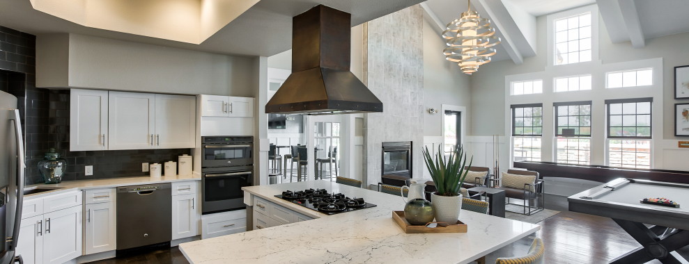 A modern open-plan kitchen with an island in the middle, stove and many appliances