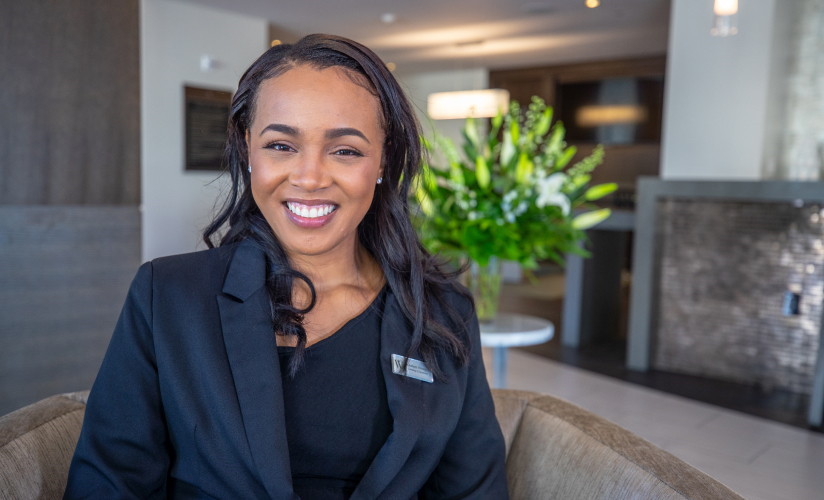 A woman wearing a suit jacket, smiling at the camera