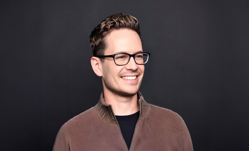 A man wearing glasses smiling